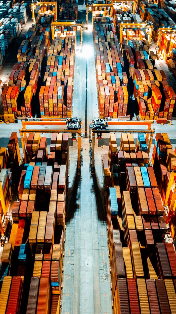 Crafting Captivating Headlines: Your awesome post title goes here Aerial view of organized cargo containers in a brightly lit warehouse at night.